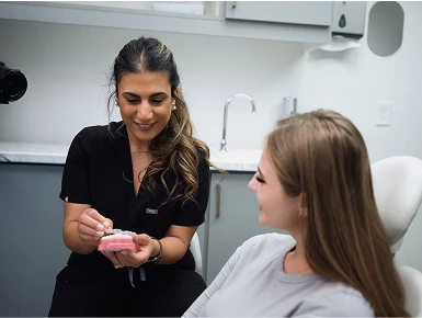 Dr. Zeidan showing a model of teeth to a patient